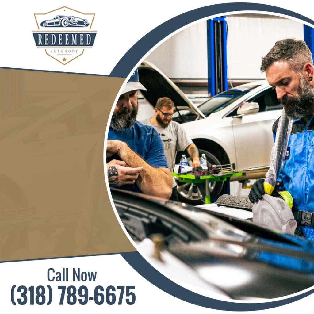 A team of auto repair technicians inspecting a car's engine bay and preparing body panels inside a repair facility.