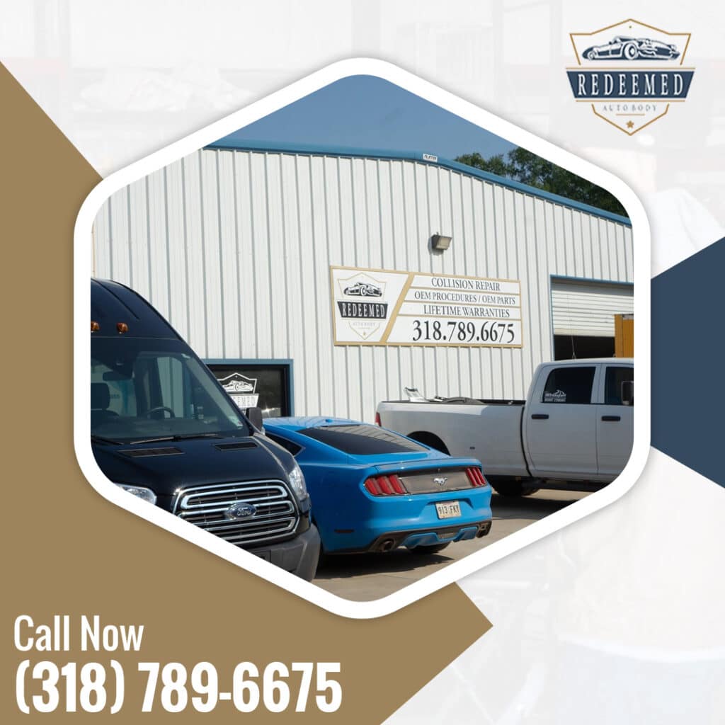 Exterior of the Redeemed Auto Body shop building with vehicles parked outside, displaying signage for collision repair and lifetime warranties.