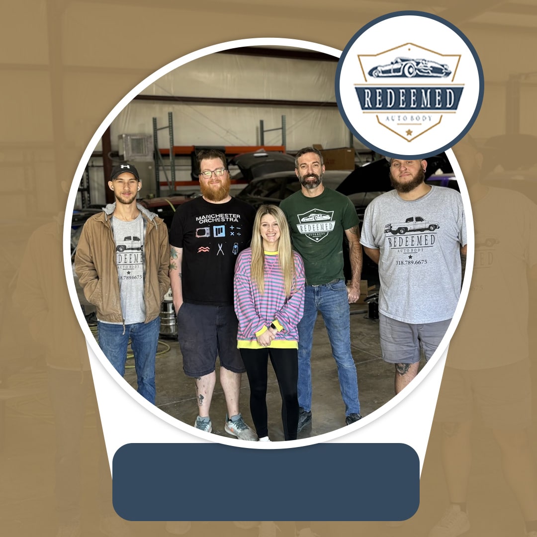 Group portrait of five auto body technicians and staff posing together inside a well-equipped auto repair and paint shop.